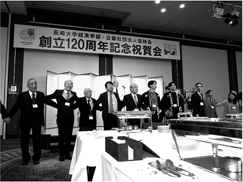 祝賀会の後、長崎高商校歌「暁星淡く」を合唱する参加者。親族がOBの鈴木市長（左から2番目）も輪に加わる。